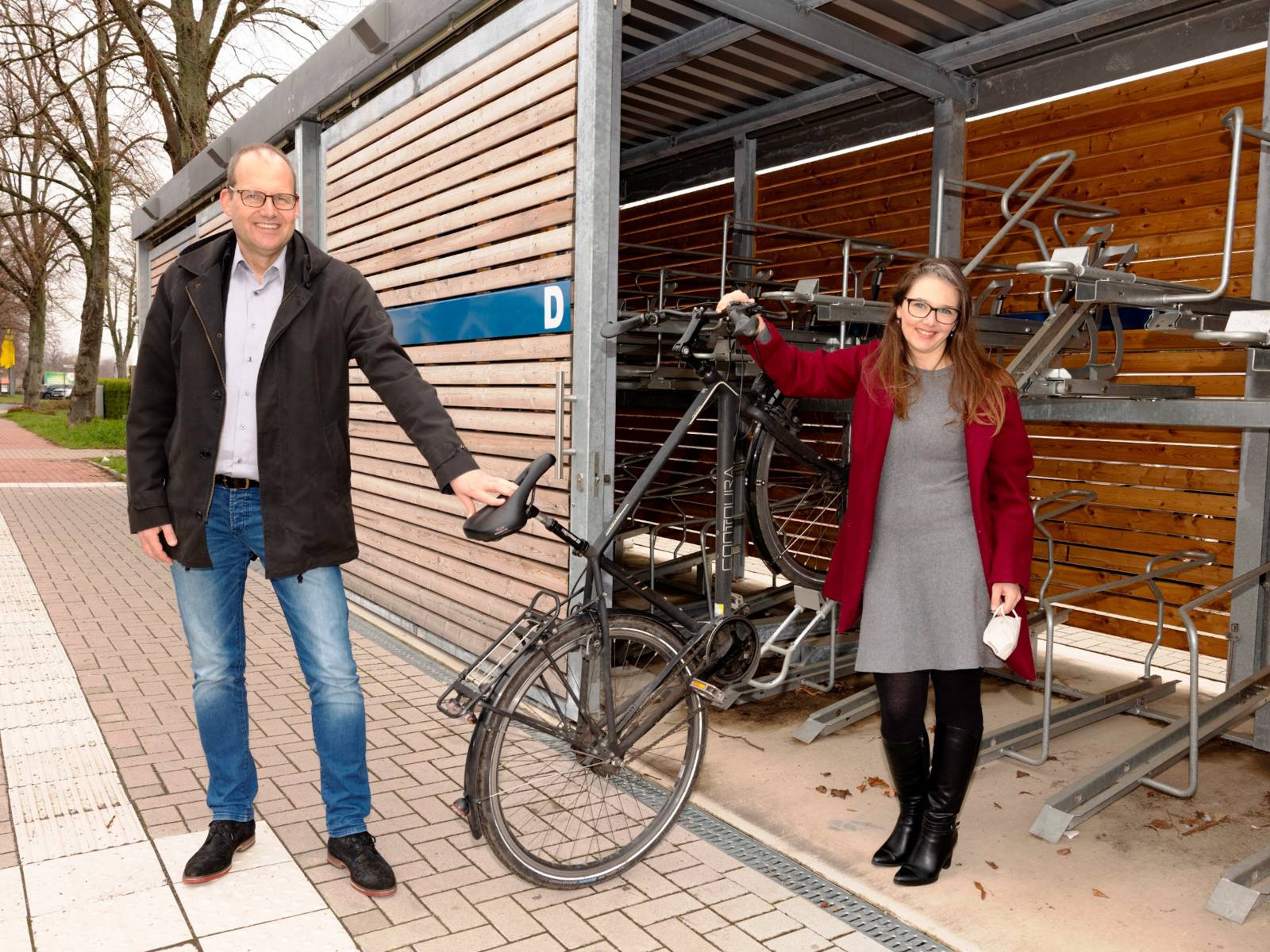 Ein Mann und eine Frau vor einer modernen Fahrradgarage